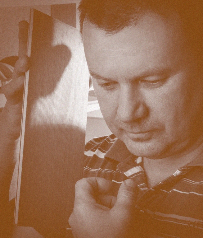 Róbert Palatinus inspecting wood veneer in his workshop for a handmade table tennis blade